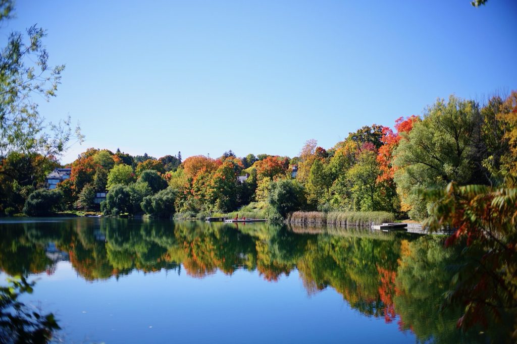 Autumn trees reflected in the calm water of McKay Lake in Ottawa, Ontario